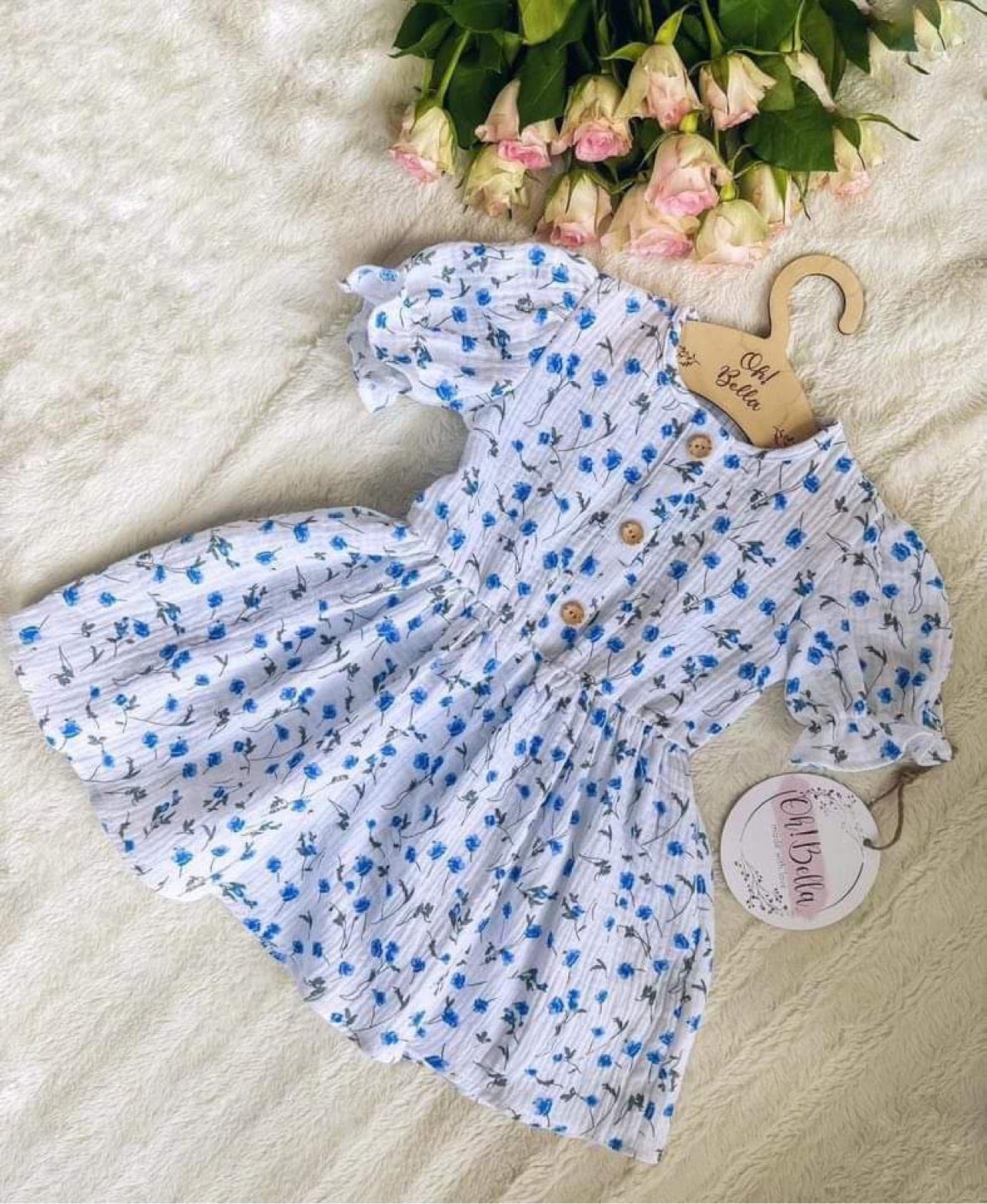 Meisjes Jurkje ‘Fenna’ Mousseline Met Korte Mouwen Knoopjes Met Elastiek Taille Wit Met Blauwe Bloemetjes Print